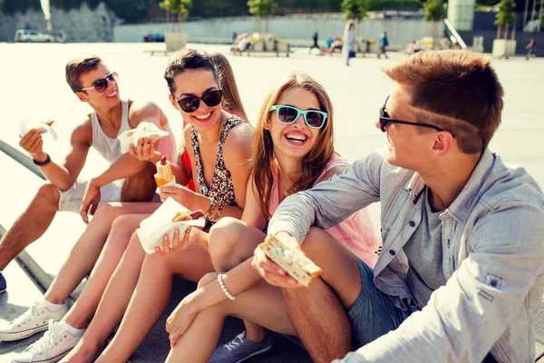 Groupe d'amis souriants assis sur la place de la ville — Photo