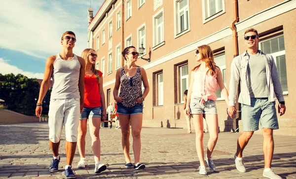 Groep lachende vrienden wandelen in de stad — Stockfoto