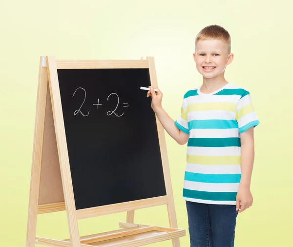 Happy little boy with blackboard and chalk — Stock Photo, Image