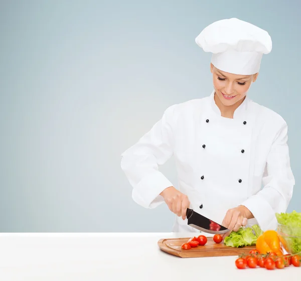 Sonriente hembra chef cortar verduras —  Fotos de Stock