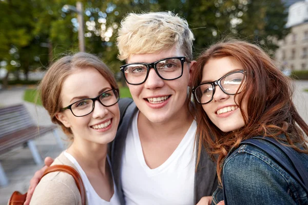 Happy teenage students in eyeglasses at campus — Stock Photo, Image