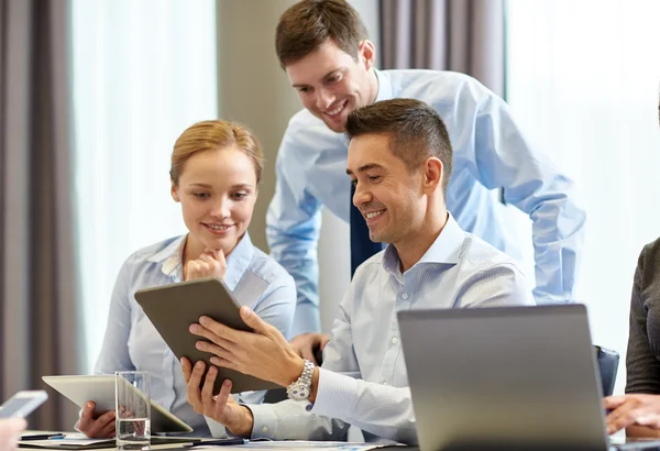 Pessoas de negócios sorridentes com tablet pc no escritório — Fotografia de Stock