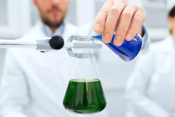 Close up of scientist filling test tubes in lab — Stock Photo, Image