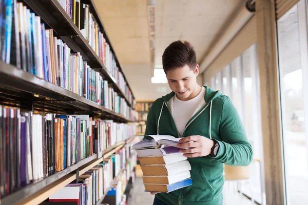 Gelukkig student of man met boek in bibliotheek — Stockfoto