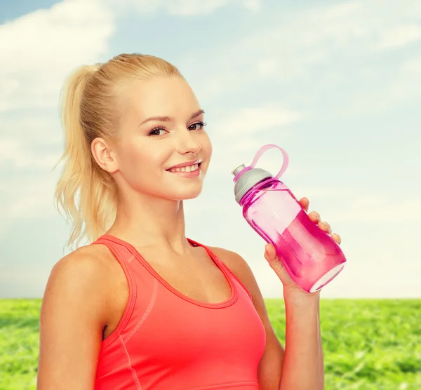 Sorrindo mulher desportiva com garrafa de água — Fotografia de Stock