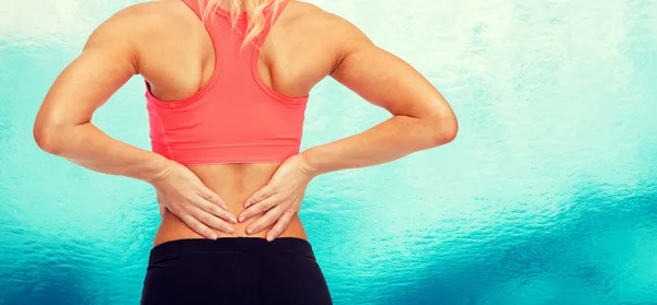 Close up of sporty woman touching her back — Stock Photo, Image