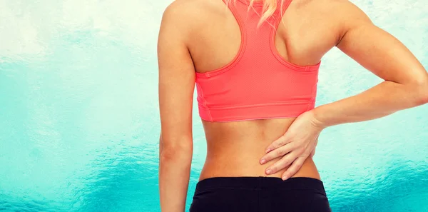 Close up of sporty woman touching her back — Stock Photo, Image