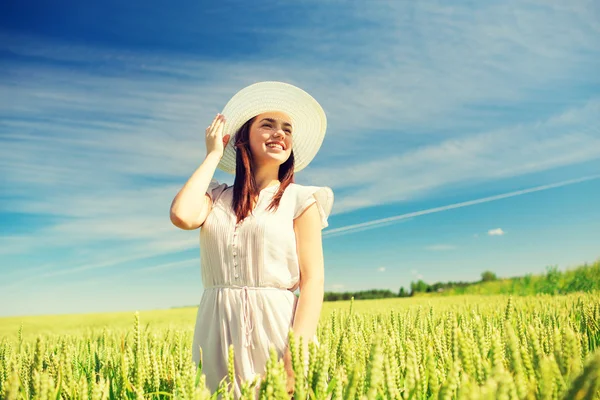 Jonge vrouw in stro hoed op granen veld glimlachen — Stockfoto