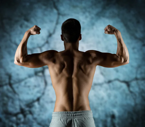 Jovem homem ou fisiculturista mostrando bíceps — Fotografia de Stock