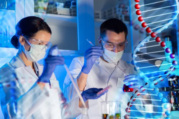 Wetenschappers met pipetten en reageerbuizen in lab — Stockfoto