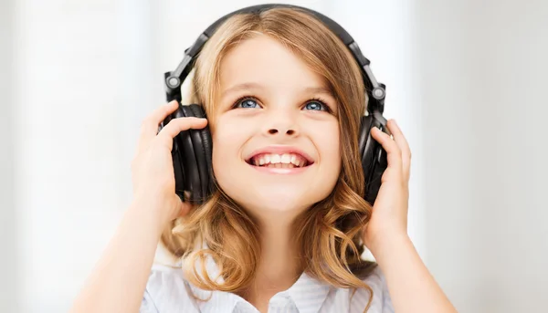 Niña con auriculares en casa — Foto de Stock