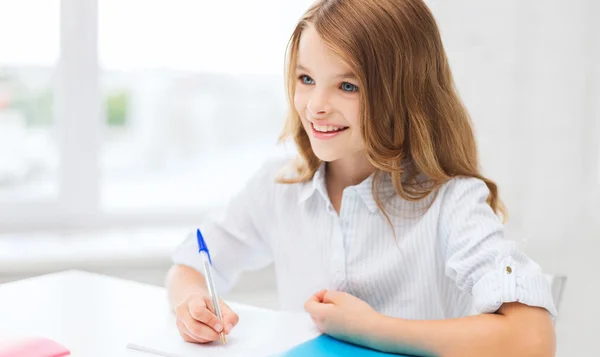 Dziewczyna studentów pisania w notesie w szkole — Zdjęcie stockowe