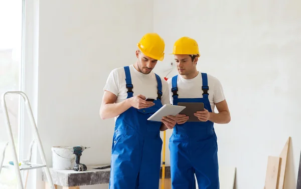 Builders with tablet pc and equipment indoors — Stock Photo, Image