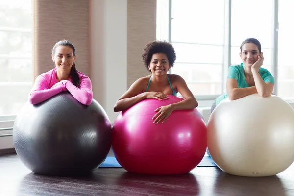 Skupina usmívající se žen s míčky cvičení v tělocvičně — Stock fotografie
