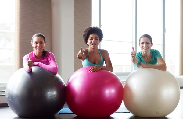 Grupp leende kvinnor med träningsbollar i gym — Stockfoto