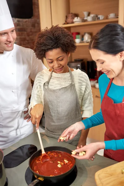 Щасливі жінки і шеф-кухар готують на кухні — стокове фото