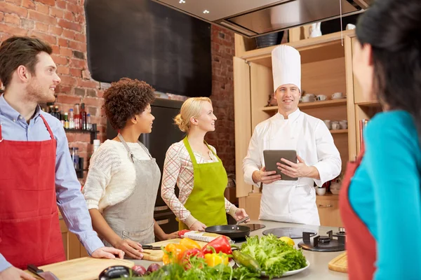 Happy friends with tablet pc in kitchen — Stock Photo, Image