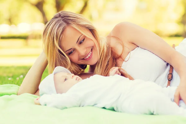 Glad mamma liggande med lilla bebis på filt — Stockfoto