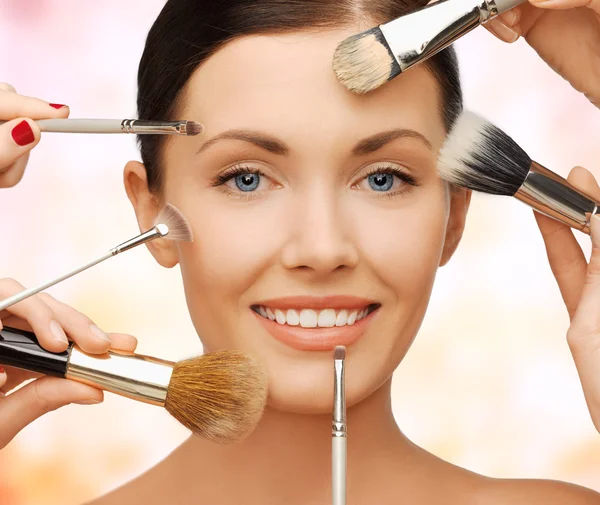 Happy woman applying professional make-up — Stock Photo, Image