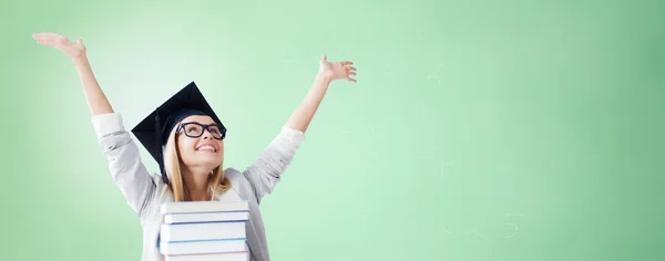 Felice studente in mortaio bordo tappo con libri — Foto Stock