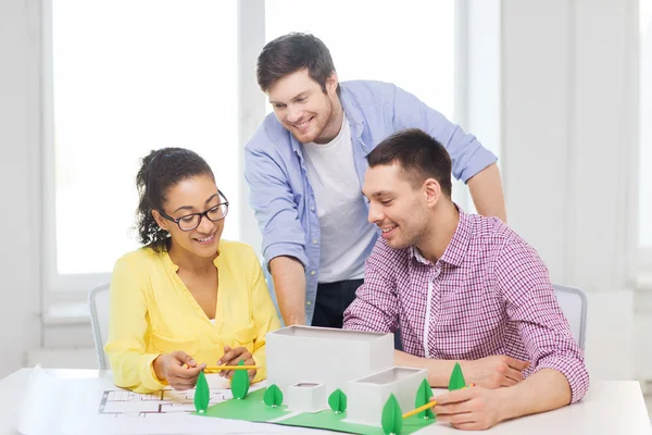 Arquitectos sonrientes trabajando en la oficina — Foto de Stock