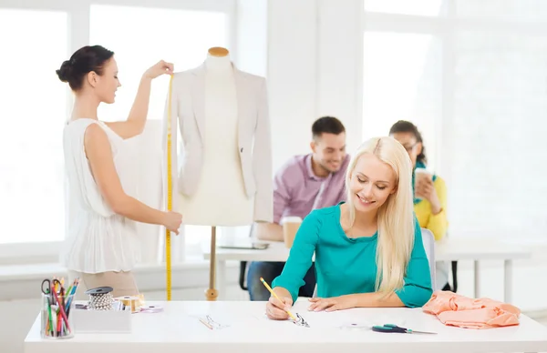 Diseñadores de moda sonrientes trabajando en la oficina — Foto de Stock