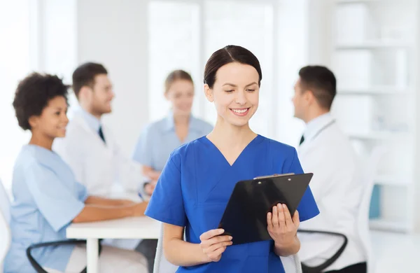 Zufriedener Arzt über Gruppe von Sanitätern im Krankenhaus — Stockfoto