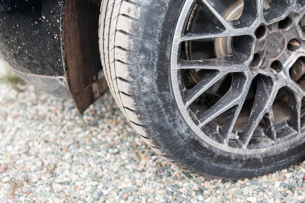 Close up of dirty car wheel on ground — Stock Photo, Image