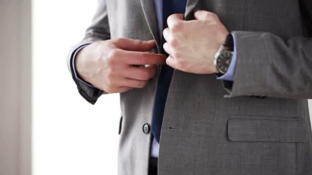 Zblízka muže v obleku, upevnění tlačítko na sako — Stock video