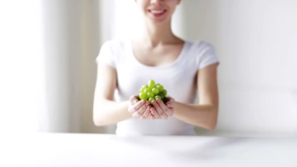 Крупным планом молодая женщина показывает зеленый гроздь винограда — стоковое видео