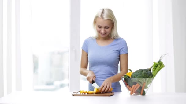 Smiling young woman chopping squash at home — Stock Video