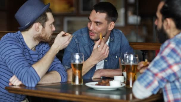 Щасливі чоловіки друзі п'ють пиво в барі або пабі — стокове відео