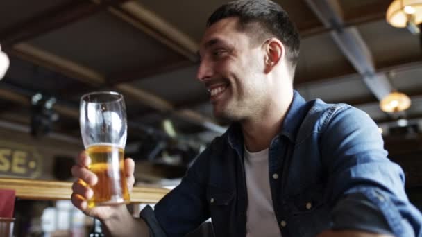 Gelukkig jonge man drinken bier bij bar of pub — Stockvideo