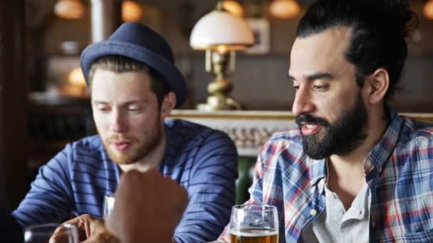 Счастливые мужчины, пьющие пиво в баре или пабе — стоковое видео