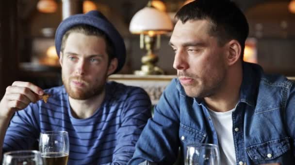 Amigos varones felices bebiendo cerveza en el bar o pub — Vídeo de stock