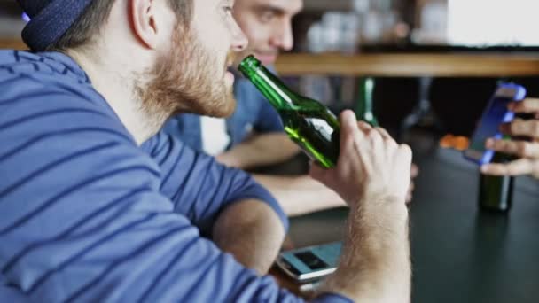 Mannelijke vrienden met smartphones drinken bier bij bar — Stockvideo