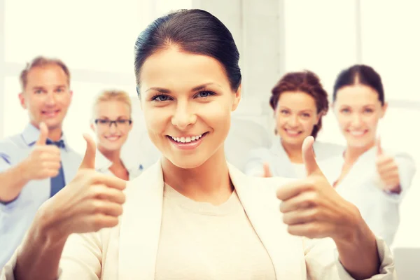 Zakenvrouw duimen opdagen in office — Stockfoto