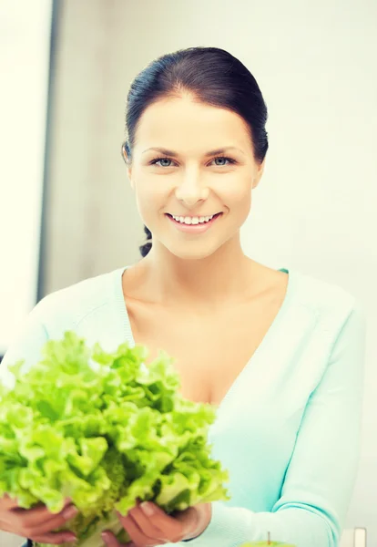 Mulher na cozinha com folhas de salada verde — Fotografia de Stock