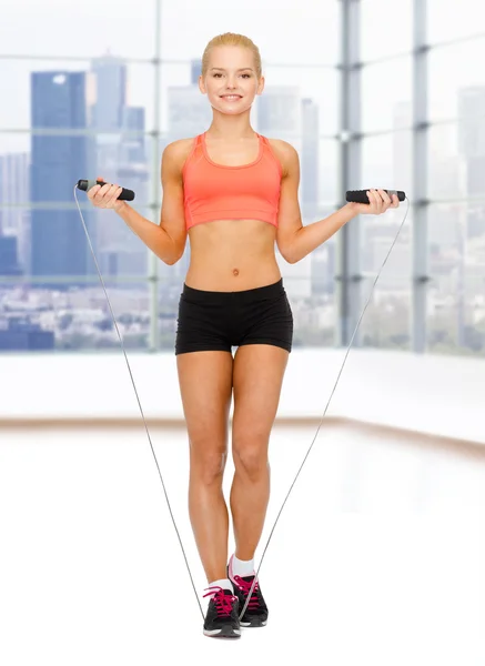 Smiling sporty woman jumping  with skipping rope — Stock Photo, Image