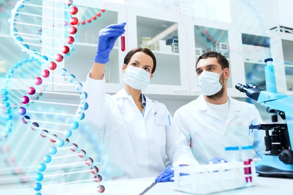 Scientists with test tubes making research in lab — Stock Photo, Image