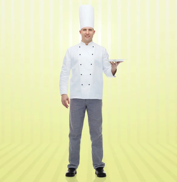 Happy male chef cook showing empty plate — Stock Photo, Image