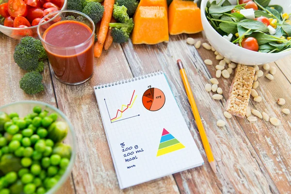 close up of ripe vegetables and notebook on table