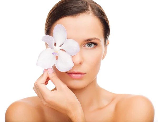 Mulher relaxada com flor de orquídea sobre o olho — Fotografia de Stock