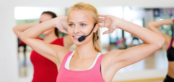 Grupo de personas sonrientes haciendo ejercicio en el gimnasio — Foto de Stock