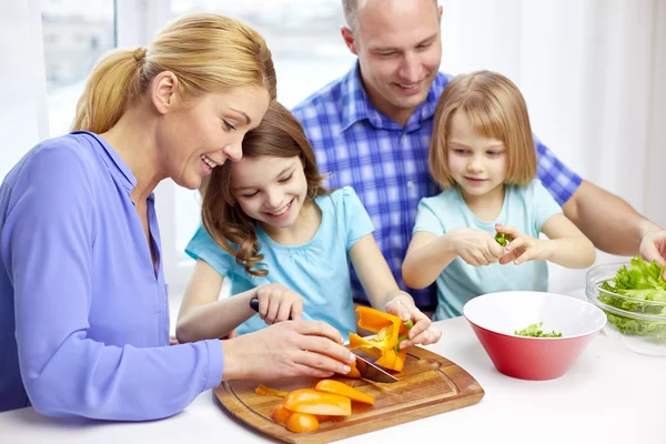 Familia feliz con dos niños cocinando en casa — Foto de Stock