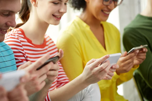 Primer plano de los estudiantes con teléfonos inteligentes en la escuela — Foto de Stock