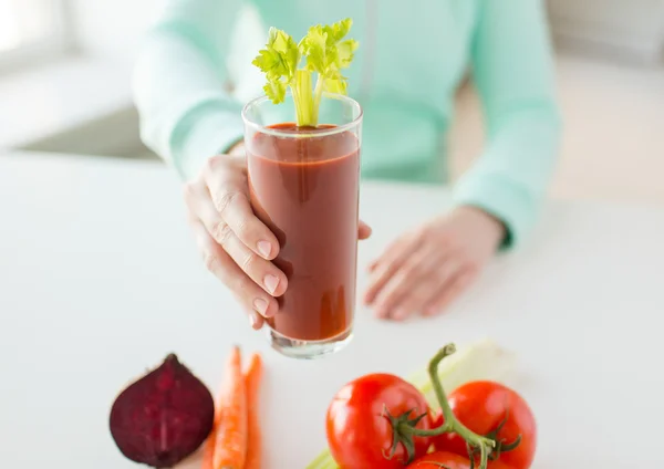 Close up of woman hands with juice and vegetables — Stock Photo, Image