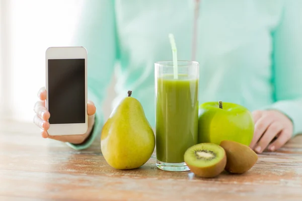 Primer plano de las manos de la mujer teléfono inteligente y jugo de frutas —  Fotos de Stock