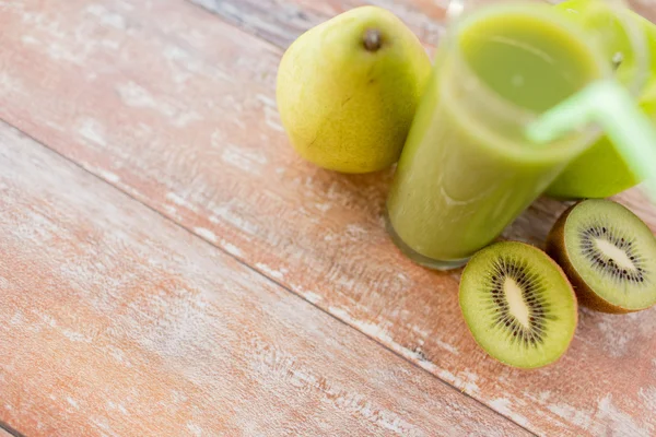 Primer plano de jugo verde fresco y frutas en la mesa — Foto de Stock