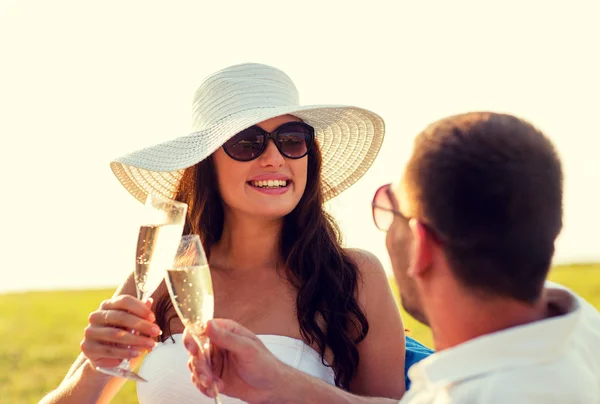 Улыбающаяся пара пьет шампанское на пикнике — стоковое фото